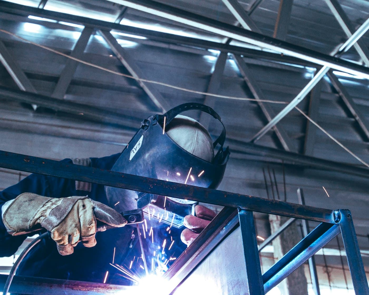 A skilled worker at work in a large industrial hall